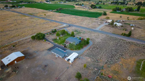 an aerial view of a house with a yard and a lot of flower plants