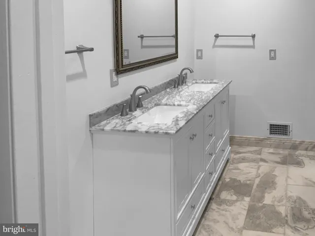 a bathroom with a granite countertop sink and a mirror