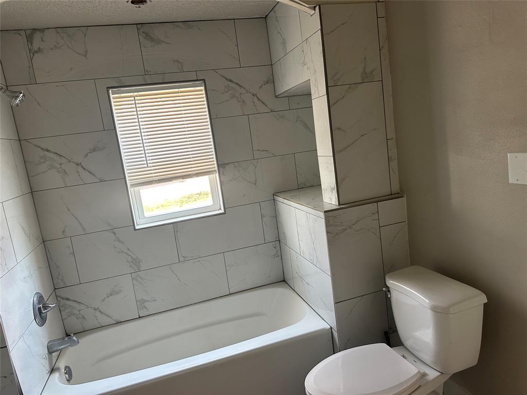 801 East Gentry Street Hamilton, TX 76531 - Photo 10 of 21 a bathroom with a toilet and bathtub