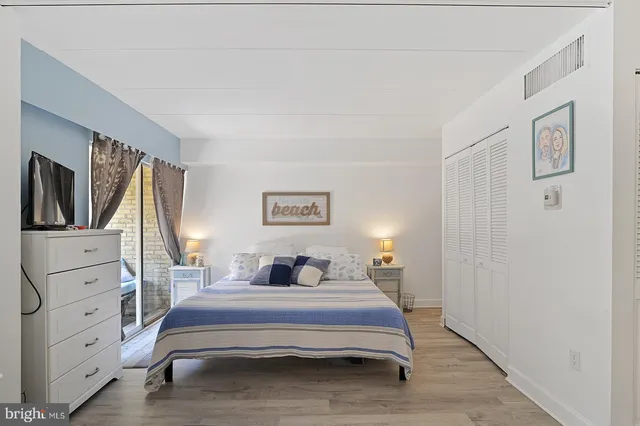 a bedroom with a bed and a flat tv screen on dresser