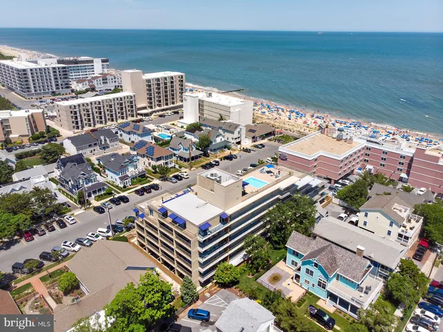 an aerial view of a residential apartment building with outdoor space and lounge chairs