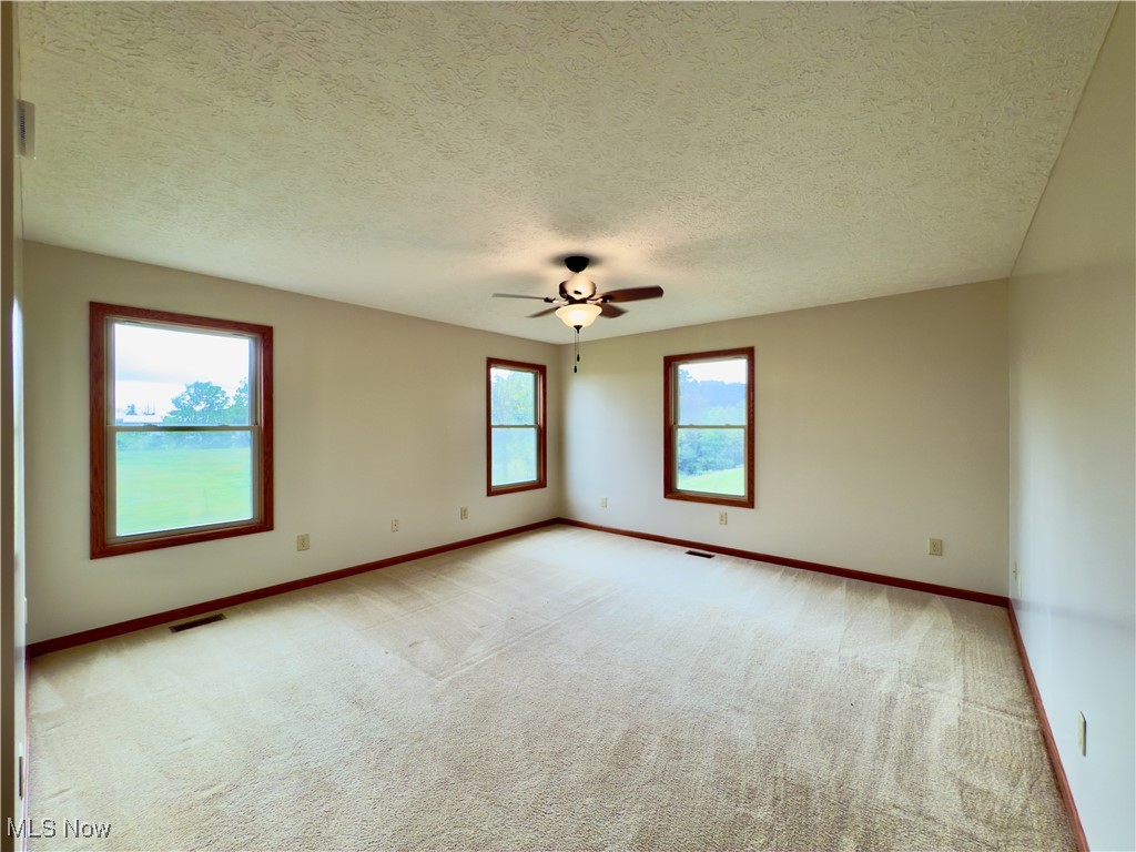 2109 Bell Road Vincent, OH 45784 - Photo 12 of 49 Unfurnished room with light carpet, a textured ceiling, and a ceiling fan