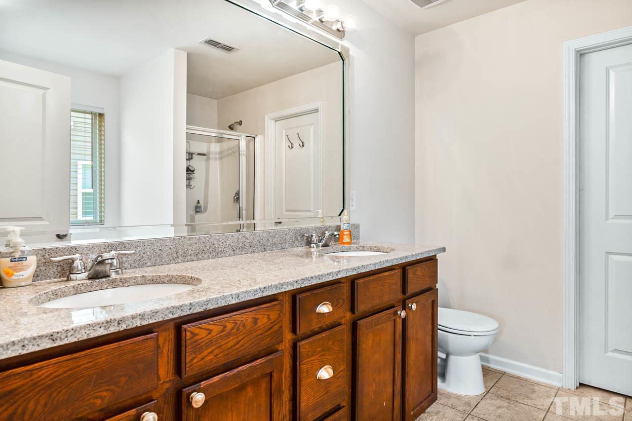 3540 Eastern Branch Road Raleigh, NC 27610 - Photo 33 of 35 a bathroom with a granite countertop sink a toilet and a mirror