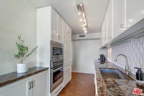 a kitchen with stainless steel appliances a sink a stove and a window