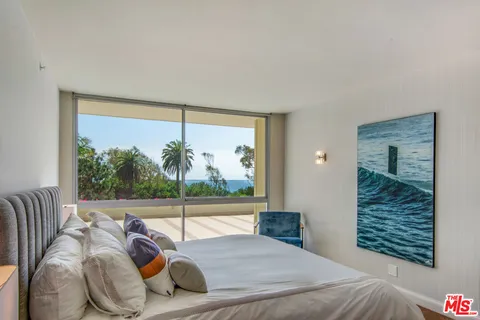 a bed room with a bed and a large window