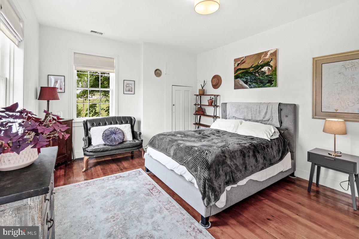 1498 Mckinstrys Mill Road Union Bridge, MD 21791 - Photo 30 of 54 a spacious bedroom with a bed and wooden floor