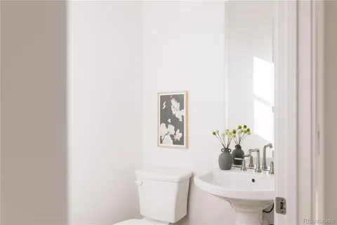 a bathroom with a toilet a sink and a mirror