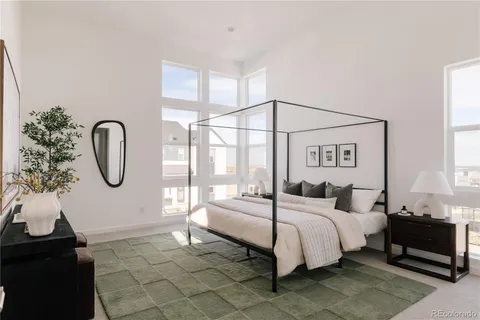 a bedroom with a bed a potted plant and a large window