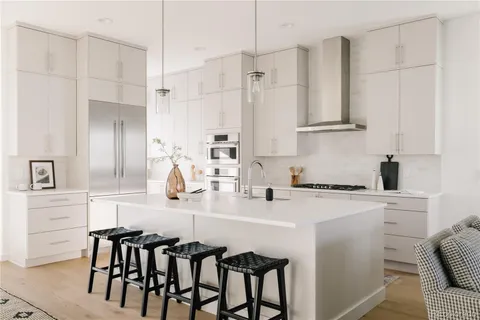 a kitchen with granite countertop white cabinets and stainless steel appliances
