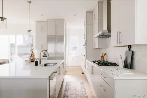 a kitchen with white cabinets and appliances