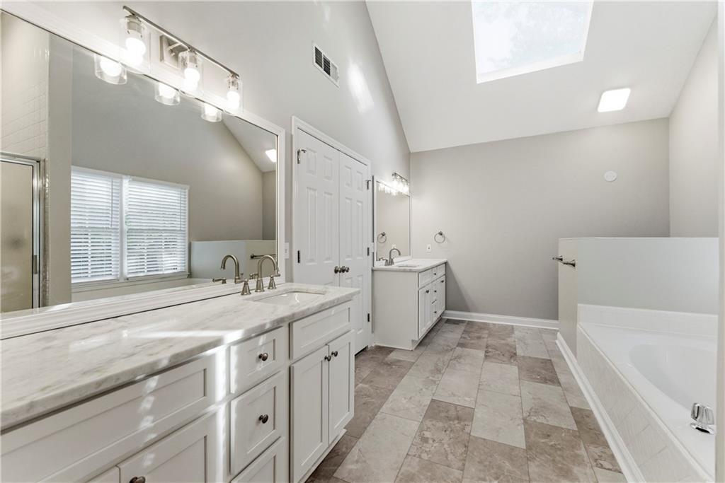 1043 Sterling Ridge Chase Northeast Marietta, GA 30062 - Photo 12 of 14 a spacious bathroom with a tub sink and mirror