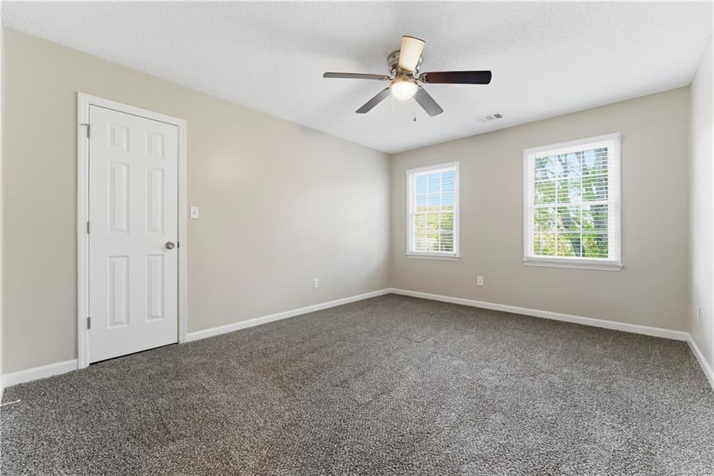 1043 Sterling Ridge Chase Northeast Marietta, GA 30062 - Photo 9 of 14 an empty room with windows and fan