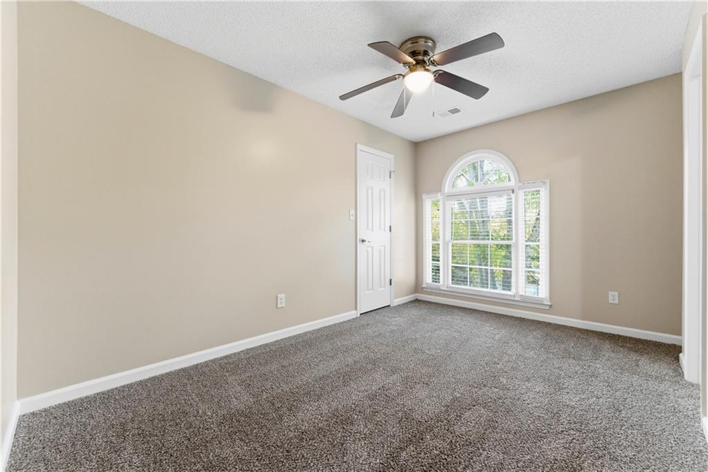 1043 Sterling Ridge Chase Northeast Marietta, GA 30062 - Photo 10 of 14 an empty room with a chandelier fan and windows