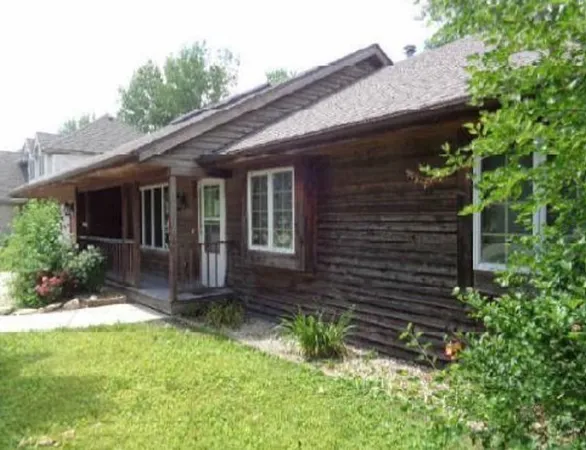 a view of house with a yard and potted plants