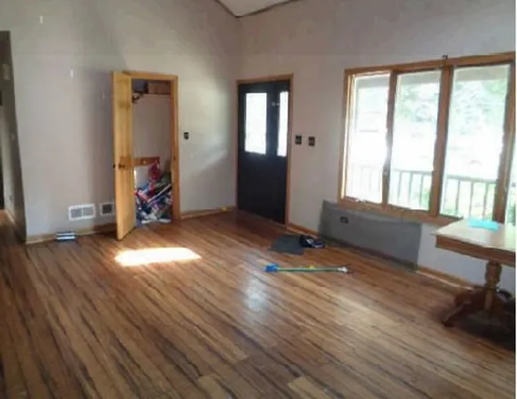 a view of empty room with wooden floor and windows