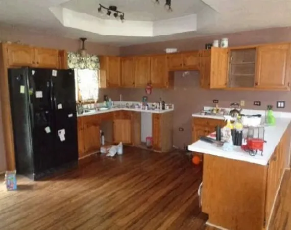 a kitchen with sink refrigerator and cabinets