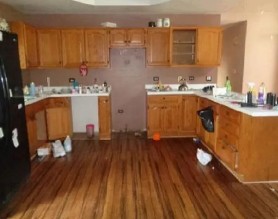 a kitchen with wooden floors and wooden cabinets