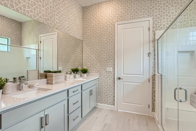 a bathroom with a double vanity sink mirror and shower