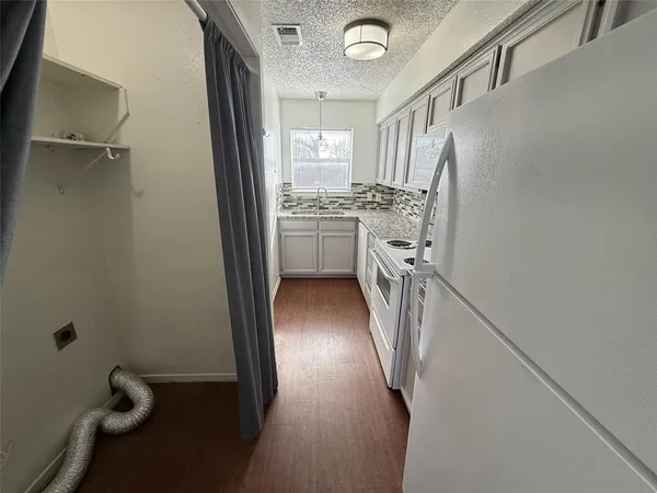 a view of a kitchen from a corridor