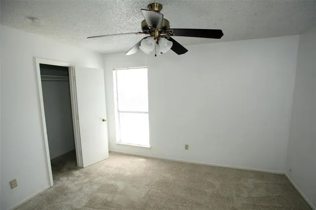 a view of empty room with ceiling fan