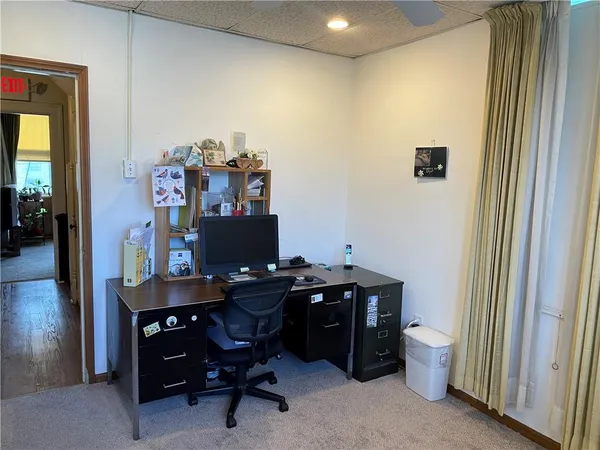 a view of a workspace with furniture and a window