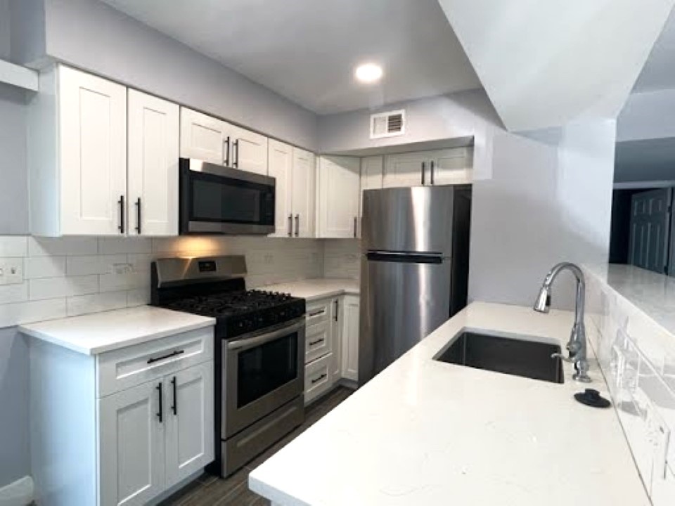 2504 Manor Circle, Unit A Austin, TX 78723 - Photo 4 of 17 a kitchen with a sink a counter top space stainless steel appliances and a window