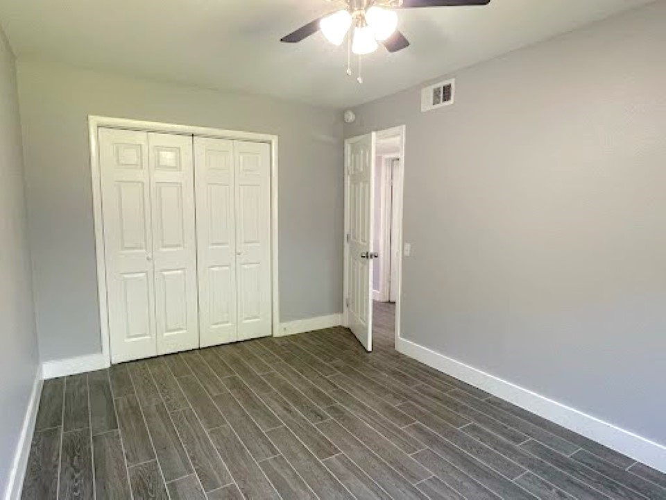 2504 Manor Circle, Unit A Austin, TX 78723 - Photo 9 of 17 an empty room with wooden floor closet and windows