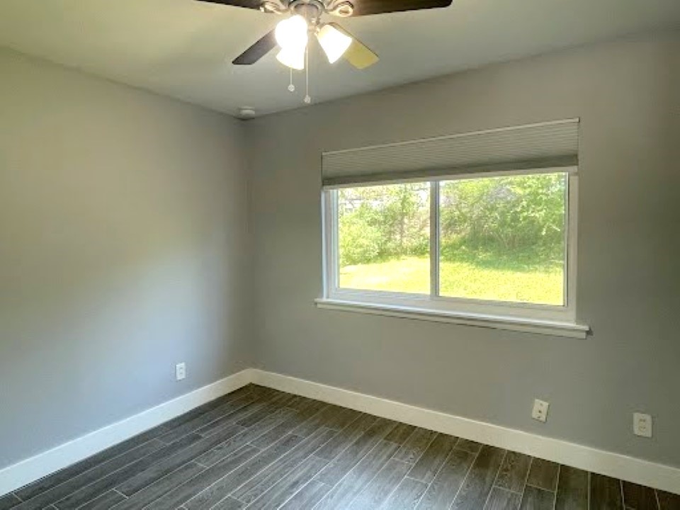 2504 Manor Circle, Unit A Austin, TX 78723 - Photo 10 of 17 a view of an empty room with wooden floor and a window
