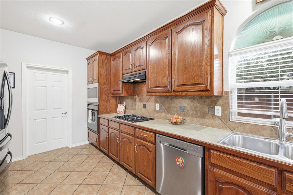 2321 Bear Run Road Arlington, TX 76001 - Photo 10 of 34 a kitchen with stainless steel appliances granite countertop a sink stove and cabinets