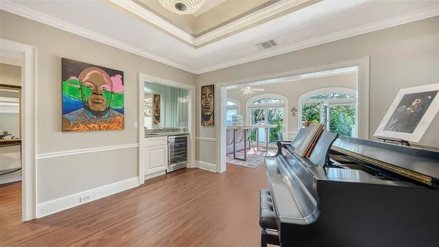 a view of a dining room with furniture a chandelier and wooden floor