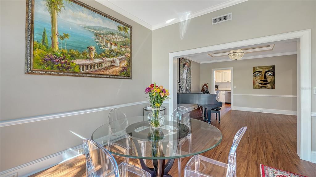 57 Bishopscourt Road, Unit 121 Osprey, FL 34229 - Photo 16 of 86 a view of a dining room with furniture a chandelier and wooden floor