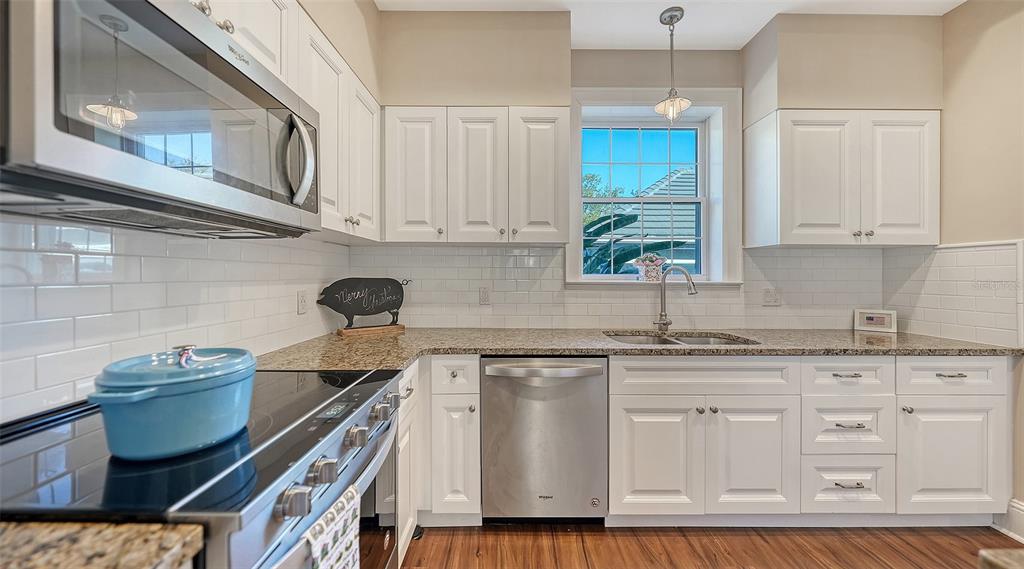 57 Bishopscourt Road, Unit 121 Osprey, FL 34229 - Photo 28 of 86 a kitchen with white cabinets and appliances