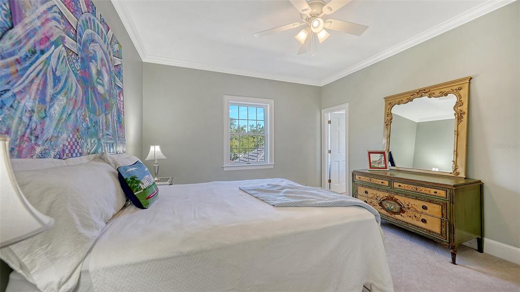 57 Bishopscourt Road, Unit 121 Osprey, FL 34229 - Photo 32 of 86 a bedroom with a bed and a chandelier