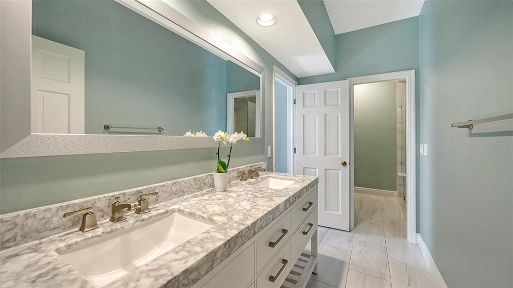 57 Bishopscourt Road, Unit 121 Osprey, FL 34229 - Photo 33 of 86 a bathroom with a granite countertop sink and a mirror