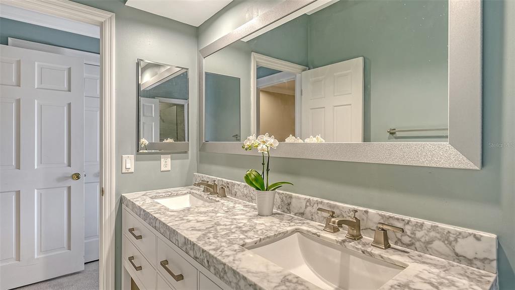 57 Bishopscourt Road, Unit 121 Osprey, FL 34229 - Photo 34 of 86 a bathroom with a granite countertop sink and a mirror