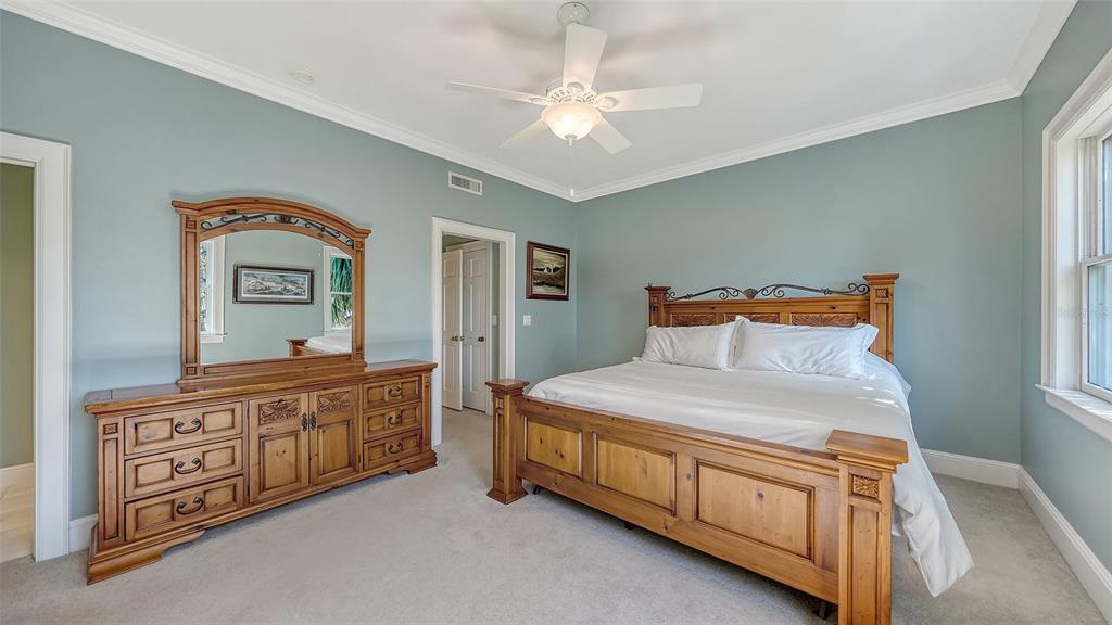 57 Bishopscourt Road, Unit 121 Osprey, FL 34229 - Photo 37 of 86 a bedroom with a bed a dresser and mirror