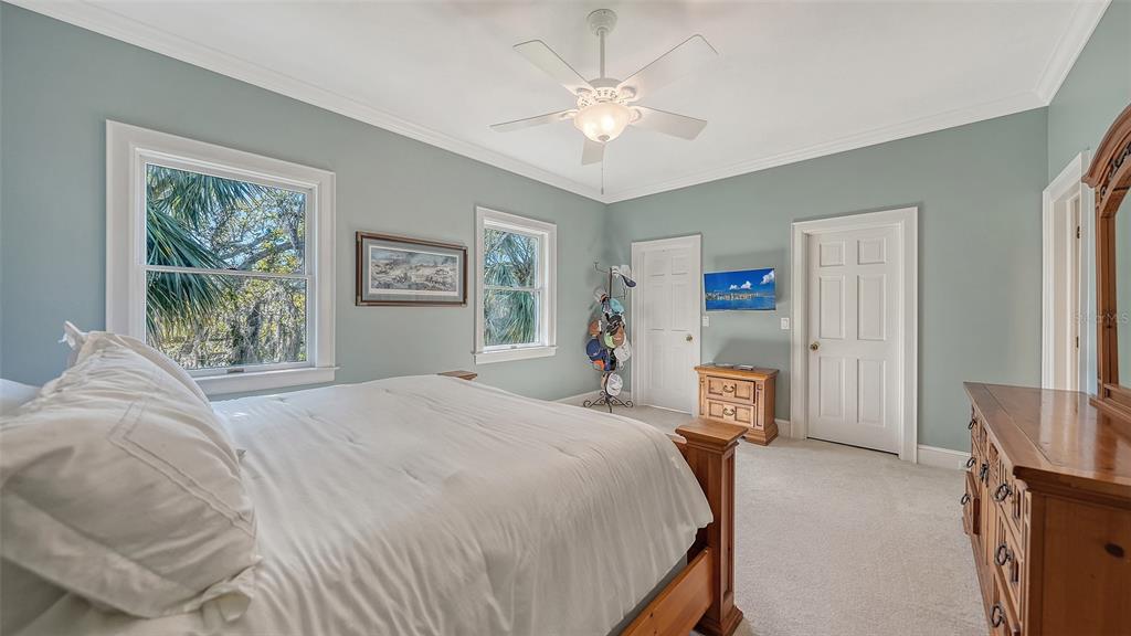 57 Bishopscourt Road, Unit 121 Osprey, FL 34229 - Photo 38 of 86 a bedroom with a large bed and a chandelier
