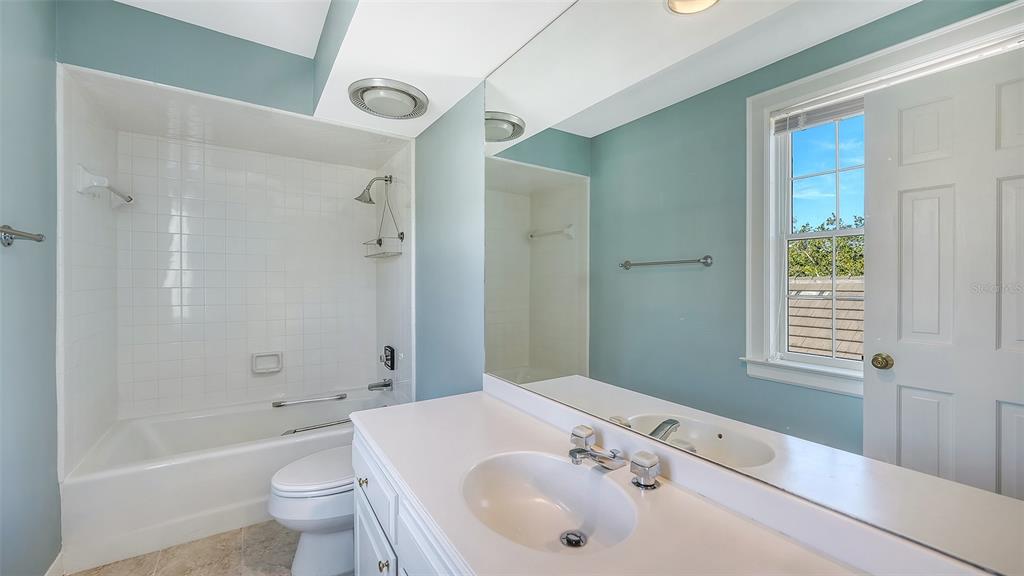 57 Bishopscourt Road, Unit 121 Osprey, FL 34229 - Photo 39 of 86 a bathroom with a bathtub shower sink vanity mirror and toilet