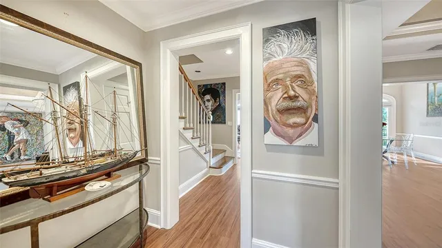 a view of a dining room with furniture a chandelier and wooden floor