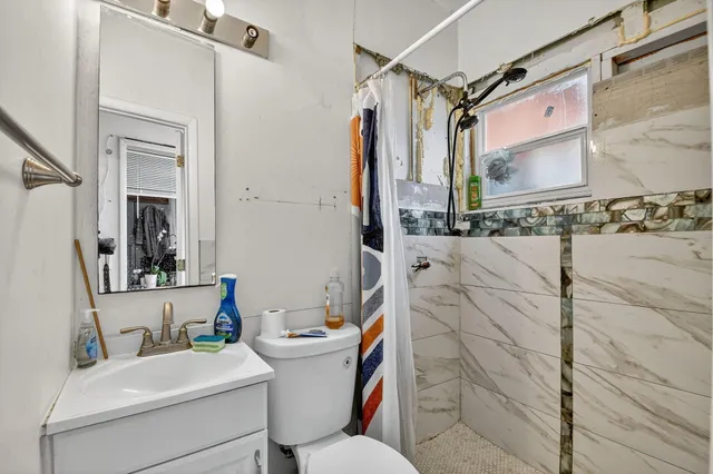 a bathroom with a sink toilet and shower