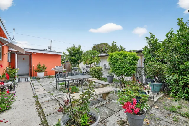 a backyard of a house with table and chairs
