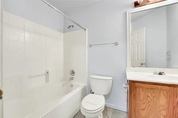 a white toilet sitting next to a bathroom sink and vanity