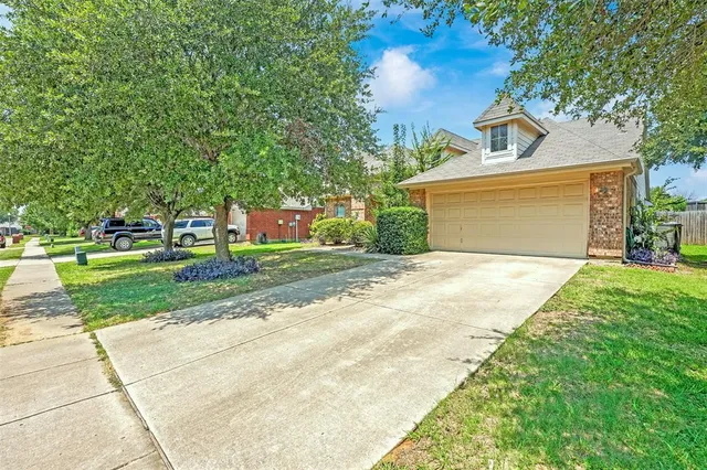 a front view of a house with a yard and trees