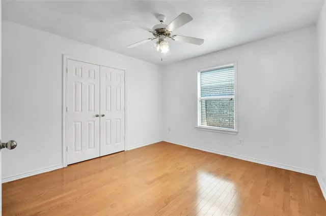 an empty room with a ceiling fan and window