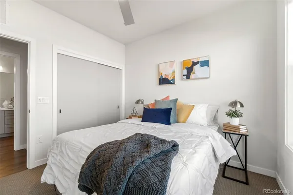 a bedroom with a bed and a painting on the wall