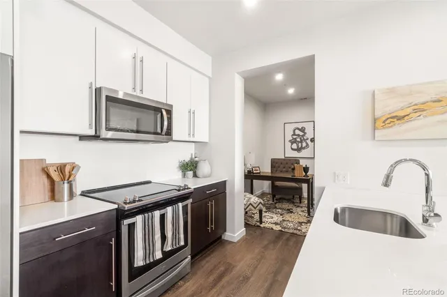 a kitchen with stainless steel appliances a microwave a table and chairs