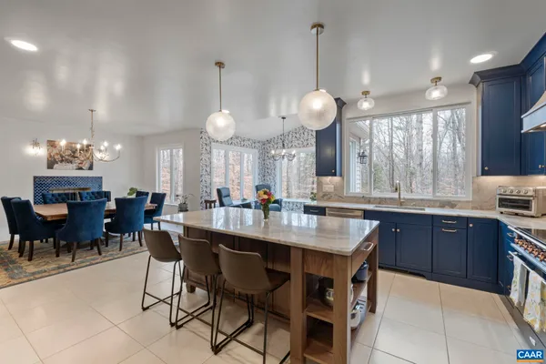 a kitchen with a dining table chairs and sink