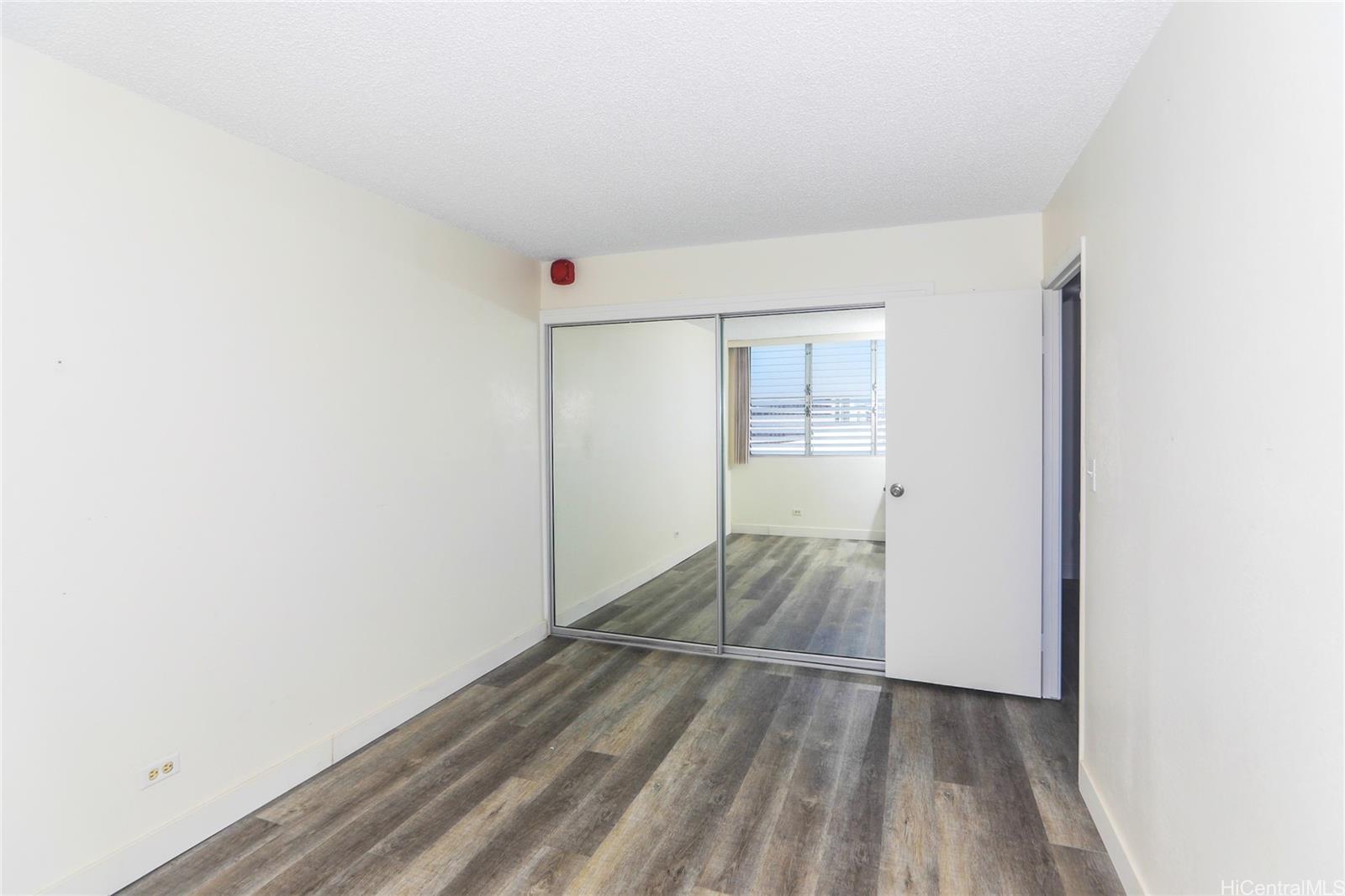 2977 Ala Ilima Street, Unit 610 Honolulu, HI 96818 - Photo 14 of 25 an empty room with wooden floor and windows