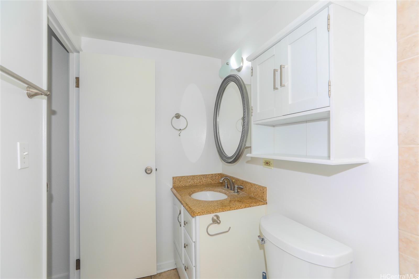 2977 Ala Ilima Street, Unit 610 Honolulu, HI 96818 - Photo 17 of 25 a bathroom with a sink a toilet and a mirror