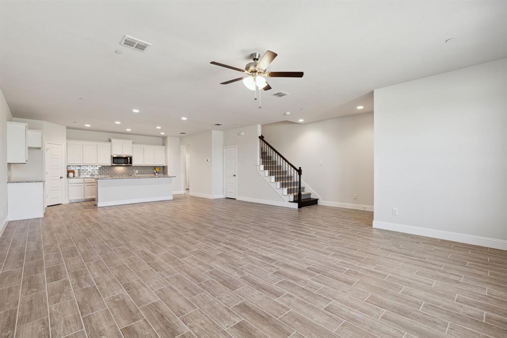 6028 Bursey Road Watauga, TX 76148 - Photo 6 of 27 a view of an empty room with wooden floor and a ceiling fan